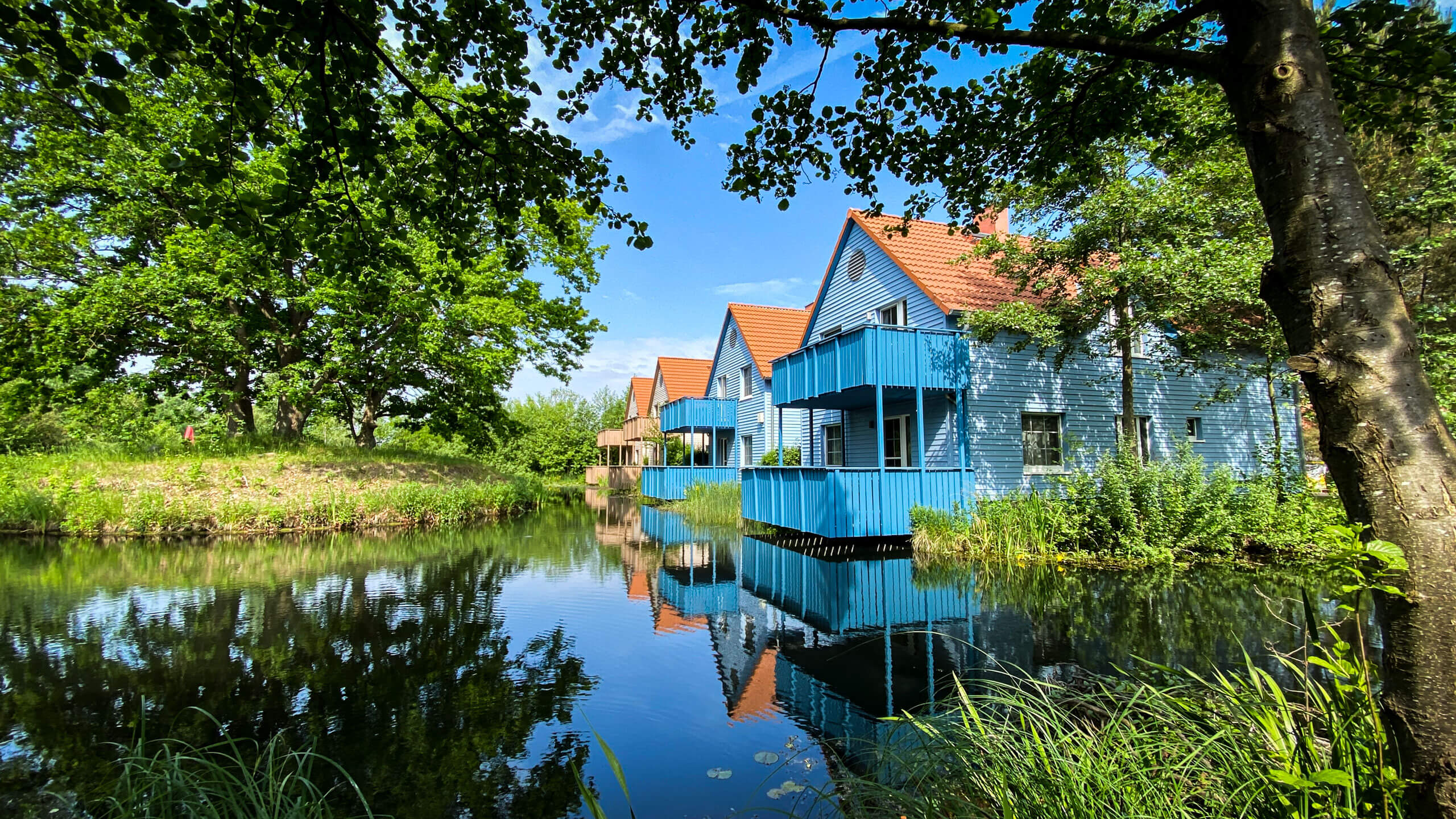 Eine Reihe von Häusern an einem Fluss. Ferienimmobilien als lukratives Renditeobjekt: Die neue Gene