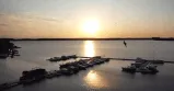 Ein Vogel fliegt über einen Hafen mit Booten und einem Sonnenuntergang, perfekt für das Maremüritz Yachthafen Resort Investmentvideo